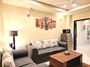 拉瓦尔品第Comfortable & Lovely 1 Bed Apt In Bahria Town的客厅配有沙发和桌子