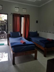 库塔捷鹏塞加拉旅馆的一间卧室设有两张床和一个带庭院的窗户。