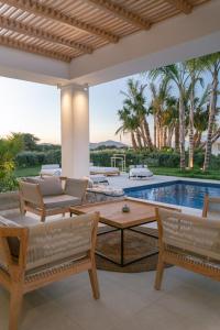 蒂加基TAF Beach Villas with Tesla的一个带桌椅的庭院和一个游泳池
