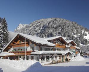 巴特欣德朗Landhotel Berghof的雪中与山间滑雪小屋