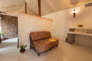 KanthalloorDeshadan Eco Valley Resort - An Eco friendly Mud House的客厅配有椅子和壁炉