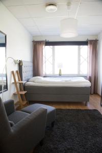 埃克舍Eksjö Longstay的一间卧室配有一张床、一把椅子和一张沙发