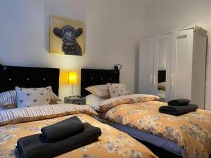 洛克比Courtyard Cottage的一间卧室配有两张床和黑色毛巾。
