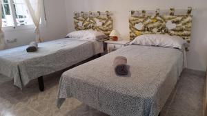 瓜尔达马尔·德尔·塞古拉Sol y Mar I的一间卧室配有两张床,并备有帽子