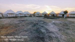 BherandiālaRann Visamo Resort的田野上的一组白色帐篷