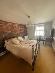 什鲁斯伯里Chandeliers 6的一间卧室设有一张大床和砖墙