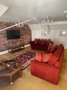 什鲁斯伯里Chandeliers 6的客厅配有红色沙发和电视