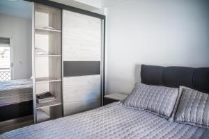 比托拉L&L Luxury Apartments的一间卧室配有一张床和一个玻璃衣柜