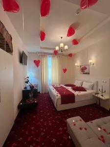布拉索夫Top Royal Central Brasov的一间卧室设有两张床,天花板上装饰有红色的心。