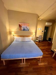 斯培西亚MaMa的一间卧室配有一张带蓝色毯子的大床