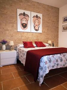 巴勒莫Zisa Home ai Cantieri Culturali的卧室配有一张床,墙上挂有两张照片