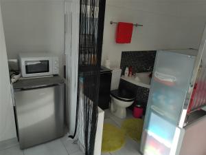 拉西约塔Charmante chambre avec vue mer的一间带微波炉和冰箱的小浴室