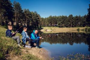 Załęcze MałeResort Stara Wieś的三人在湖上钓鱼