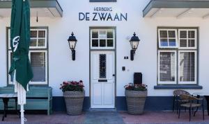 埃尔斯佩特Herberg de Zwaan Elspeet的大楼前门,大楼内设有餐厅