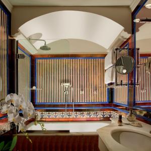 罗马Bio Hotel Raphael - Relais & Châteaux的一间带水槽和大镜子的浴室