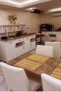 伊斯坦布尔BALPETEK HOTEL的厨房配有木桌和白色椅子