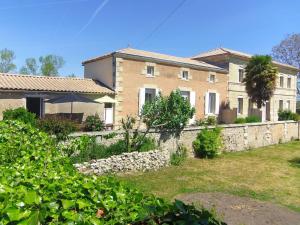 Anglade"Le gite du Petit Guilhem" Près Bordeaux Maison classée 4étoiles Meublé Tourisme piscine parc étang的一座带石墙的大型砖屋