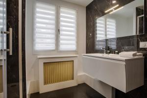多维尔Les Caravelles - Trois Pièces - Deauville Centre的一间带水槽和镜子的浴室以及窗户。