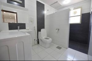 科威特诺贝洛斯公寓式酒店的白色的浴室设有卫生间和水槽。