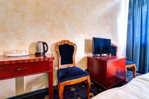 基辅Hotel Kiev Lomakin的一间卧室配有书桌、电视和椅子