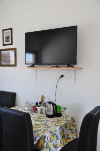 阿拉德Vastu Dead Sea apartment的餐桌和墙上的电视