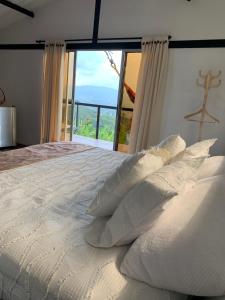 PalestinaLa Paloma Glamping的配有枕头的白色床和大窗户
