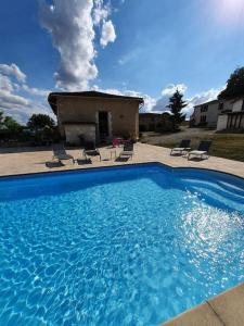 BlanzacFrench Farmhouse Retreat with pool & superb views.的一座大蓝色游泳池,位于房子前