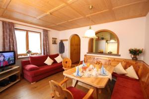 巴特欣德朗Ferienwohnungen Hennenmühle的客厅配有桌子和红色沙发