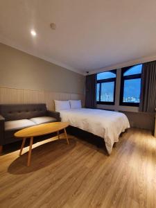 台南耀西文旅的一间卧室配有一张床、一张沙发和一张桌子