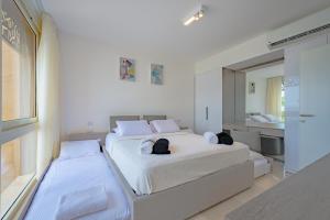 赫尔格达Mangroovy Seaview 3BR Beach and Pool Free access的一间白色卧室,配有两张床和镜子