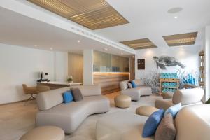 波连萨港格勒塔酒店 - 仅限成人的客厅配有白色沙发和蓝色枕头。