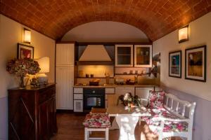 蒙塔约内博尔戈圣贝乡村民宿的一间带桌椅的厨房和一间带炉灶的厨房