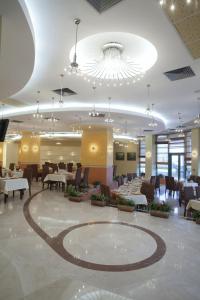 布加勒斯特Mari Vila Hotel的一间带桌椅和大吊灯的餐厅