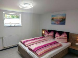 奥斯特巴特宁哈根Ferienwohnung Küstenanker的一间卧室配有一张粉色和白色床单。