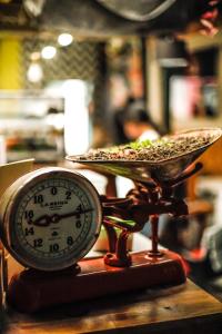 麦德林Panela Coffee Hostel的时钟和一盘规模的食物