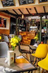 麦德林Panela Coffee Hostel的一间设有黄色桌椅和柜台的餐厅
