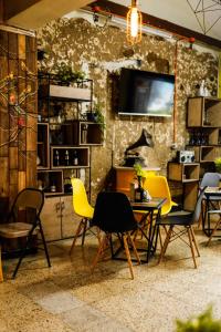 麦德林Panela Coffee Hostel的一间带椅子和桌子的房间以及一台电视