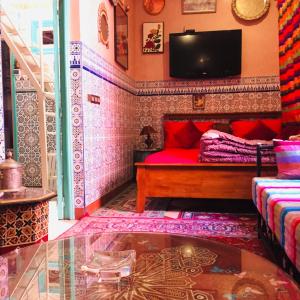 马拉喀什ALMARKAB Riad的客厅配有红色沙发和电视