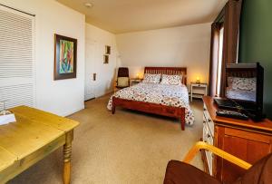 拉马巴耶奥伯格拉马米特酒店的一间卧室配有一张床、一张书桌和一台电视