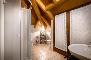 蒂拉诺Bernina Express Eco Rooms&Breakfast的浴室设有2个卫生间、水槽和浴缸。