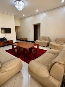 卡巴莱Makanga Hill Suites的带沙发和木桌的客厅