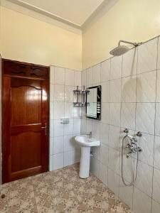 卡巴莱Makanga Hill Suites的一间带水槽、淋浴和卫生间的浴室