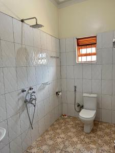 卡巴莱Makanga Hill Suites的一间带卫生间和水槽的浴室