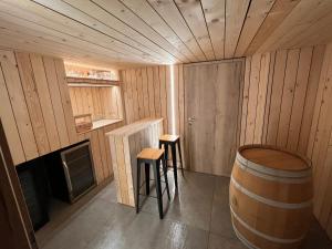 胡法利兹Gîte Chez Doumé的一间桑拿房里设有一桶和两张凳子的房间