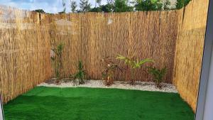 MontjolyStudio confort avec jardinet的后院设有木栅栏和绿色草地