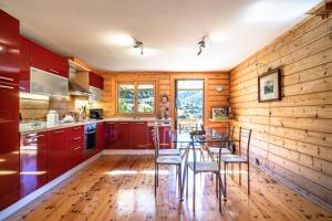 卡拉维塔Luxury Chalet Vila on Mountain Top with great view的厨房设有木墙和桌椅