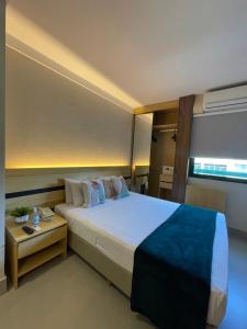 维多利亚Flat PRAIA Home Experience Dante Michelini的一间卧室配有一张大床和一张桌子