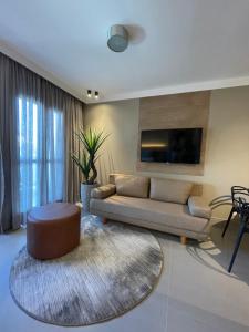 维多利亚Flat PRAIA Home Experience Dante Michelini的客厅配有沙发和桌子