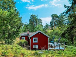 GustavsvikHoliday home SALTSJØBO的田野里带桌椅的红色棚子