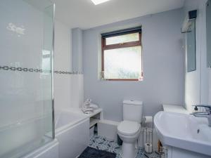 SouthleighPurlbridge Bungalow的白色的浴室设有卫生间和水槽。